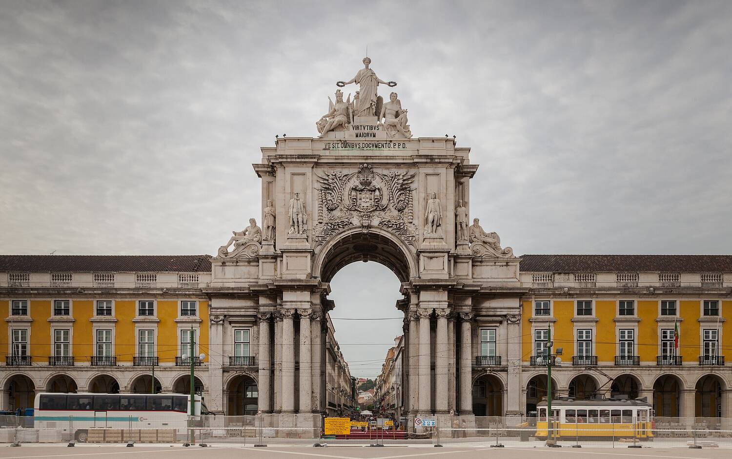 A sunlit Lisbon street with pastel buildings and a Portuguese flag, the kind of place Golden Visa applicants imagine calling home